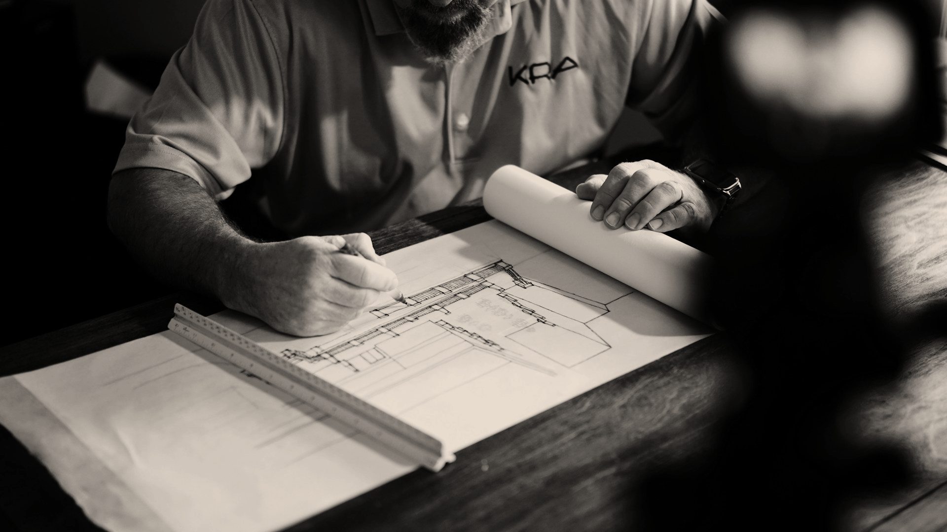 Arquiteto desenhando uma planta com lápis e régua