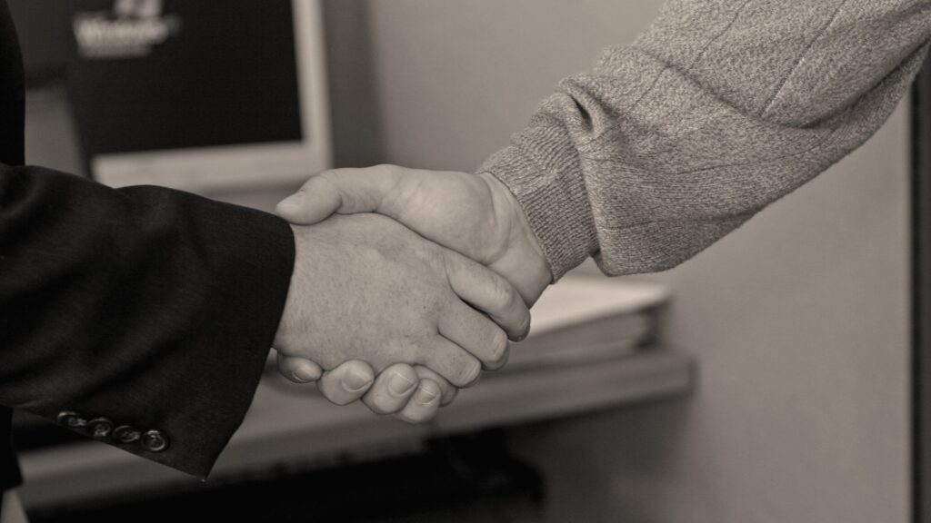 Aperto de mãos entre dois profissionais, representando confiança e reputação da empresa