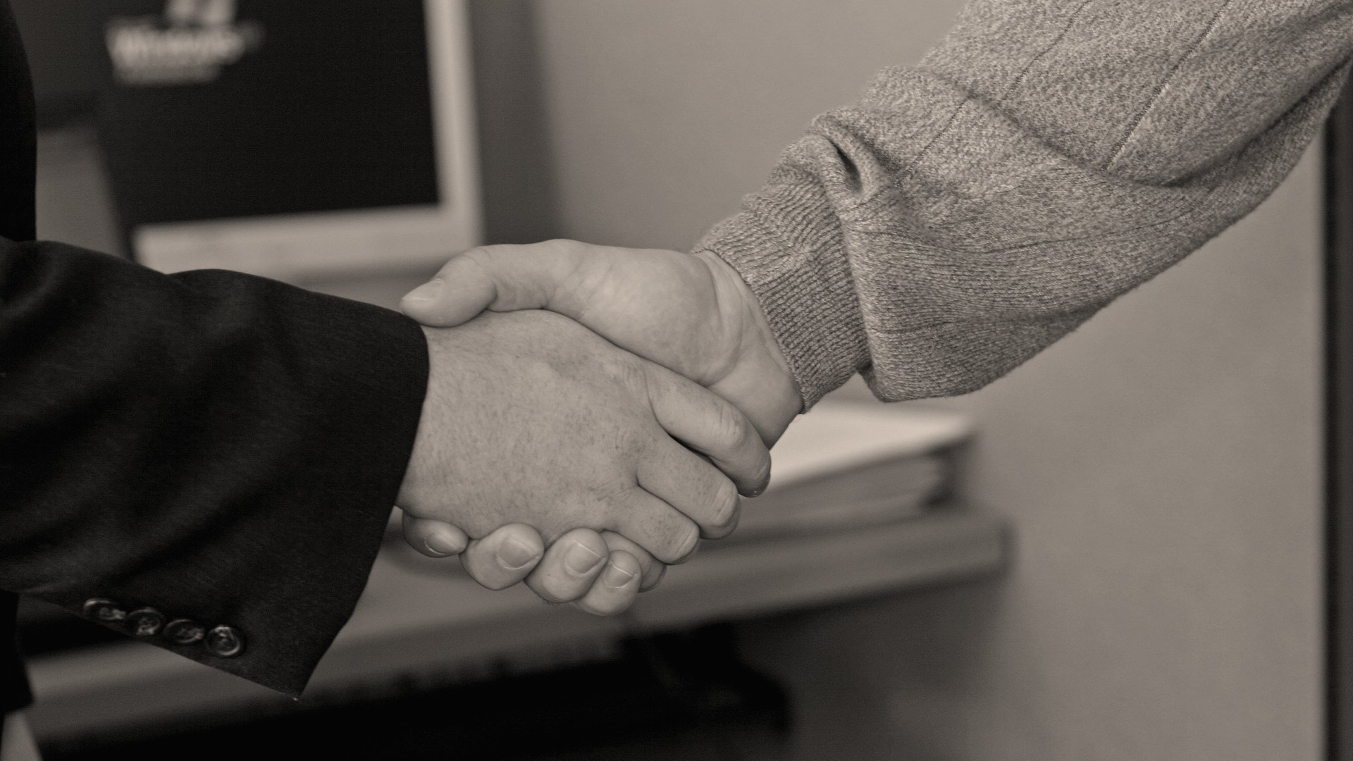 Aperto de mãos entre dois profissionais, representando confiança e reputação da empresa